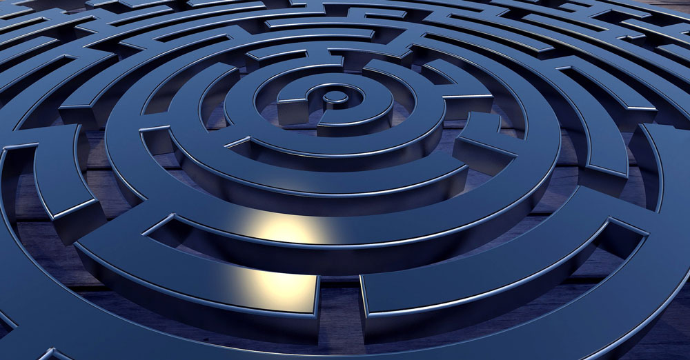 Ein blaues Labyrinth wird schräg von oben gezeigt. Es gibt viele Irrwege, die zunächst verhindern, dass du in das Zentrum des Labyrinths kommst. Ein Symbol für die Mindgames, die wir alle spielen und die zunächst verhindern, dass du herausfindest, wer du bist. 